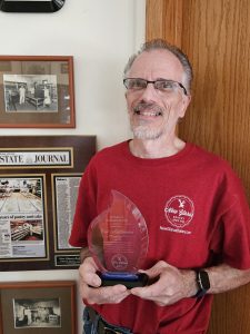 New Glarus Bakery Baker Eric holding a flame award